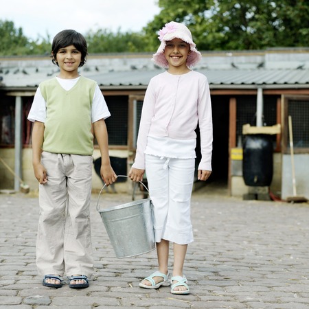Boy and girl holding a bucket togetherの写真素材