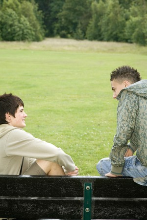 Boys sitting on the bench talkingの写真素材