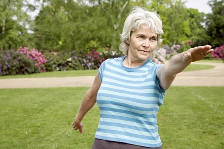 Senior woman practising yoga in the parkの写真素材