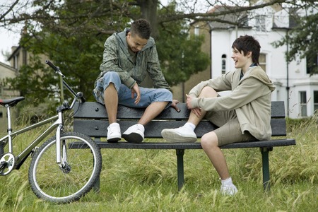 Boys sitting on the bench talkingの写真素材