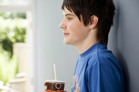 Boy holding a cup of carbonated drink
