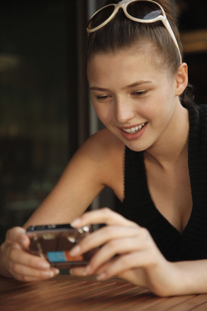 Woman looking at pictures taken in digital cameraの写真素材