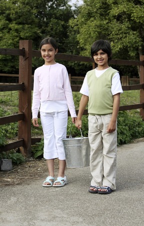 Boy and girl carrying a bucketの写真素材