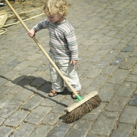 Boy holding a broomの写真素材
