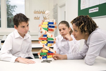 Woman teaching girl and boy using a molecular structureの写真素材