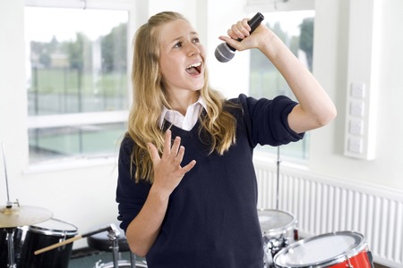 Girl singing into microphoneの写真素材