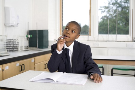 Boy with pen in deep thoughtの写真素材