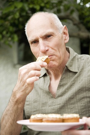 Senior man eating cakeの写真素材