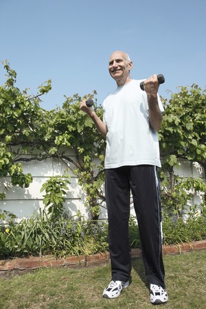 Senior man lifting dumbbellsの写真素材