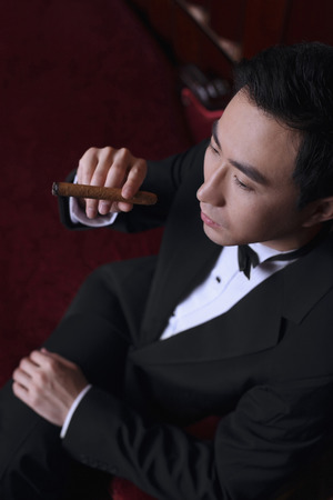Man in tuxedo holding a cigarの写真素材