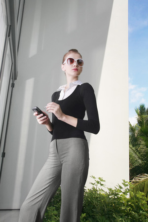 Woman in formal wear text messagingの写真素材