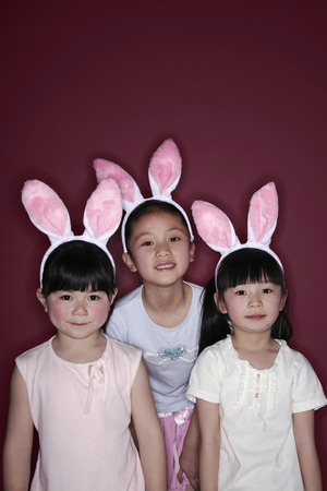 Girls with bunny headbands posing for the cameraの写真素材