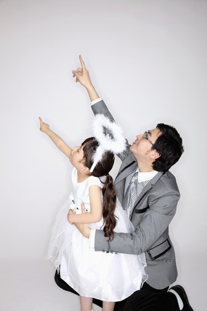 Man and girl pointing upwardsの写真素材