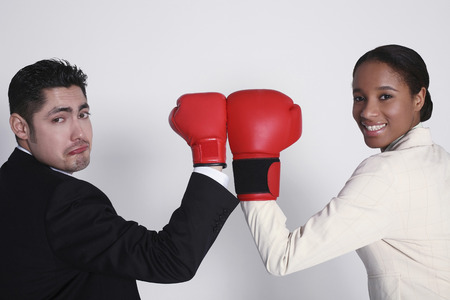 Businessman and businesswoman posing with their boxing gloves