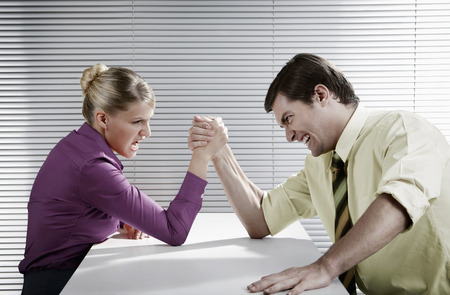Businessman and businesswoman arm wrestling