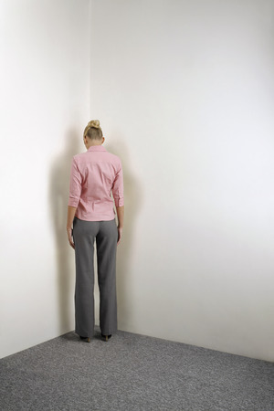 Businesswoman standing in corner of roomの写真素材
