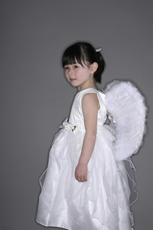 Girl wearing white dress with angel wingsの写真素材