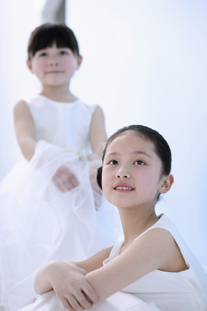 Girls in white dresses smilingの写真素材
