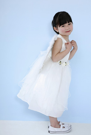 Girl wearing white dress with angel wingsの写真素材