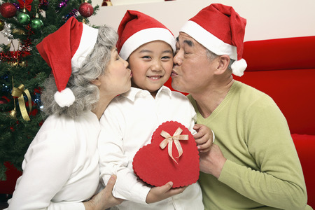 Senior man and senior woman kissing boyの写真素材