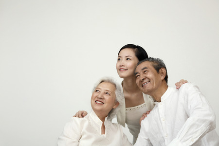 Woman and senior couple smiling while looking away