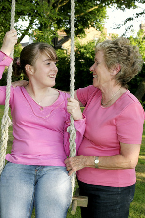 An old lady helping to swing her granddaughter