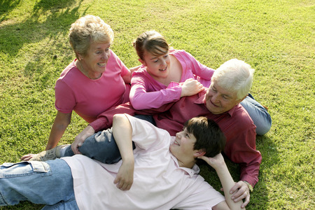 An old couple lying together with their grandchildren on the fieldの写真素材