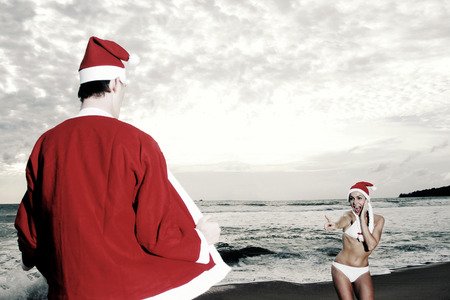 A lady in bikini screaming seeing a flasher in Santa suit exposing himself in front of herの写真素材