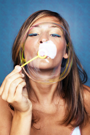 Woman blowing out a big bubbleの写真素材
