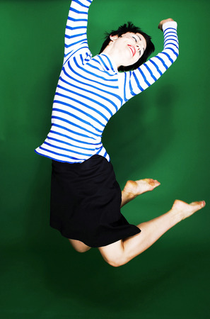Woman in blue and white stripes blouse jumping happilyの写真素材