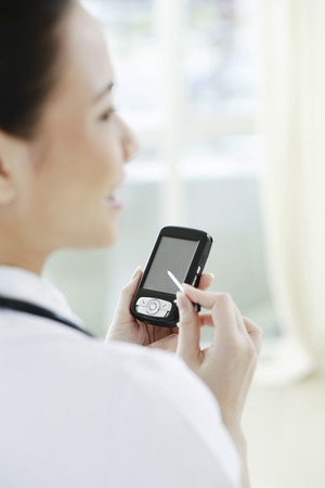 Female doctor using palmtopの写真素材