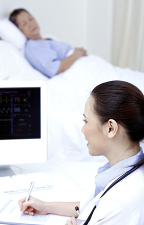 Doctor checking electrocardiogramの写真素材