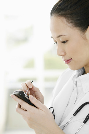 Female doctor using palmtopの写真素材