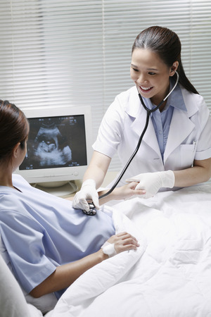 Female doctor checking on a pregnant womanの写真素材