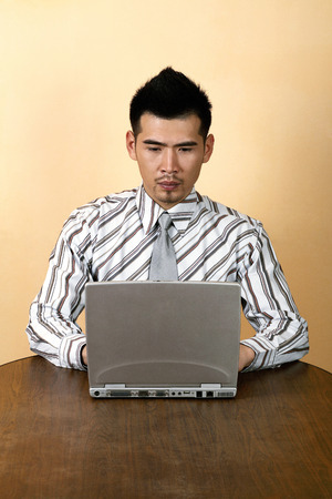 Businessman sitting at the table using laptopの写真素材