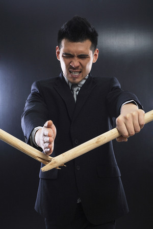 Businessman chopping stick with his bare handの写真素材