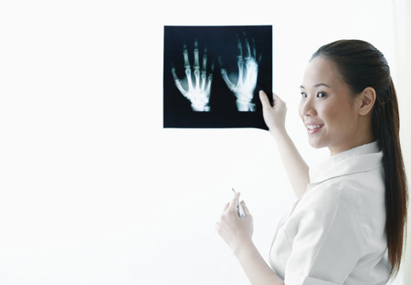 Female doctor pointing at hand x-ray