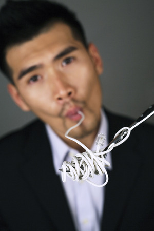 Businessman sipping in computer cableの写真素材