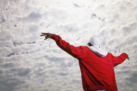 Man in hooded sweater with arms spread