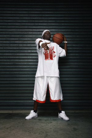 Man holding basketball pointing at the cameraの写真素材