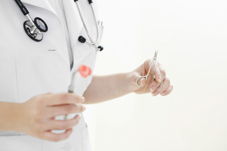 Doctor with cotton swab full of blood and a scissorsの写真素材