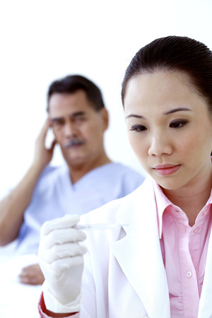 Doctor examining patient's temperatureの写真素材