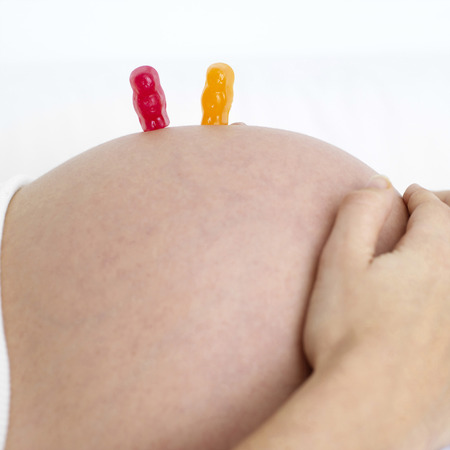 Gummi bears on a pregnant woman's stomachの写真素材