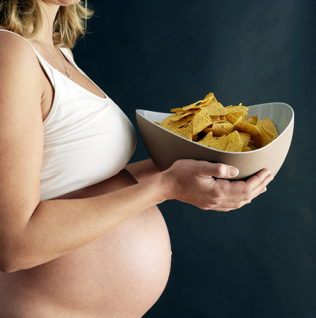 Pregnant woman holding a bowl of crisp