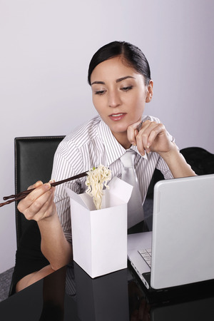 Businesswoman eating instant noodleの写真素材