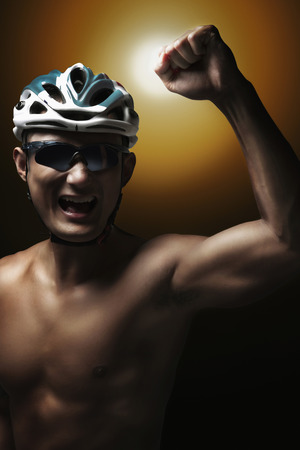 Man in cycling helmet celebrating his successの写真素材