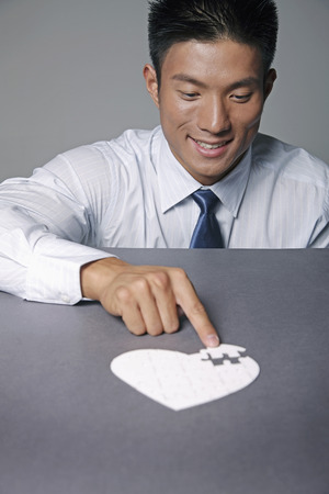 Businessman playing jigsaw puzzleの写真素材