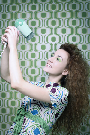 Woman blow-drying her hair with hair dryerの写真素材
