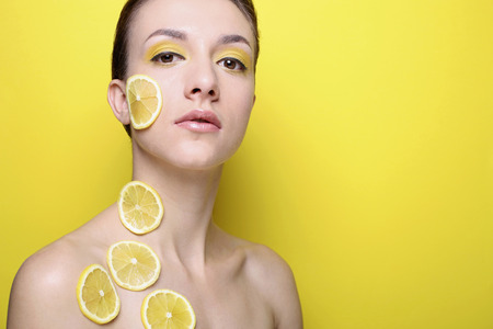 Woman with slices of lemon on her face and neckの写真素材