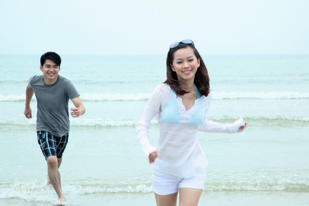 Man chasing woman on the beachの写真素材